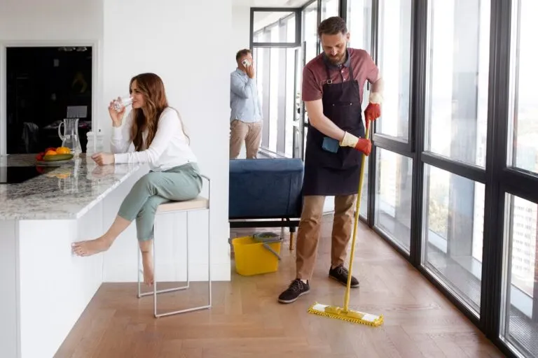 Professional cleaner with broom providing home and office cleaning in Edmonton and Calgary